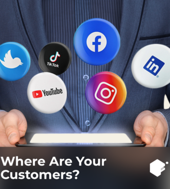 a photo of social media icons floating above a tablet in the hands of a man in a business suit