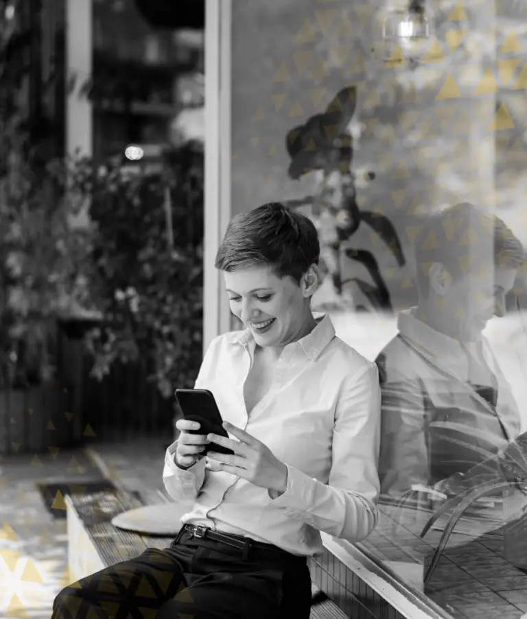 women smiling while reading messages on phone