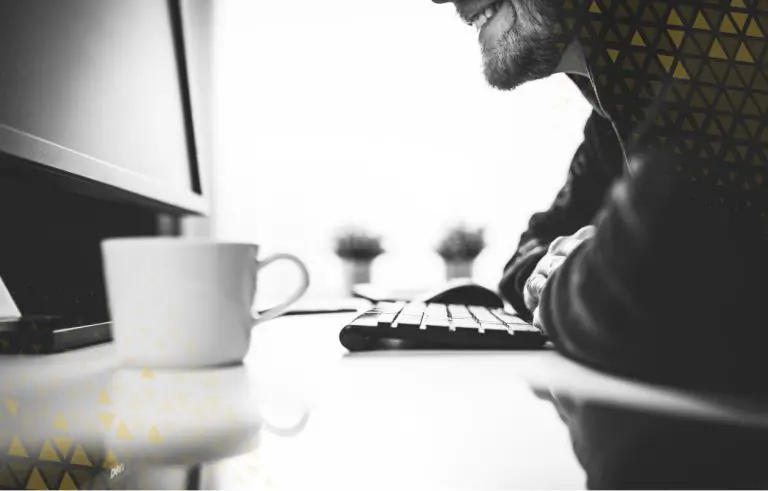 man smiling over his keyboard