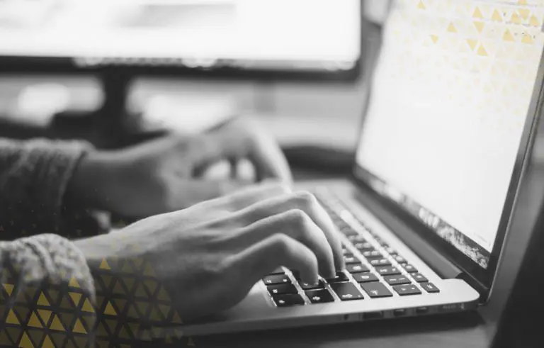 close up of hands typing on a laptop