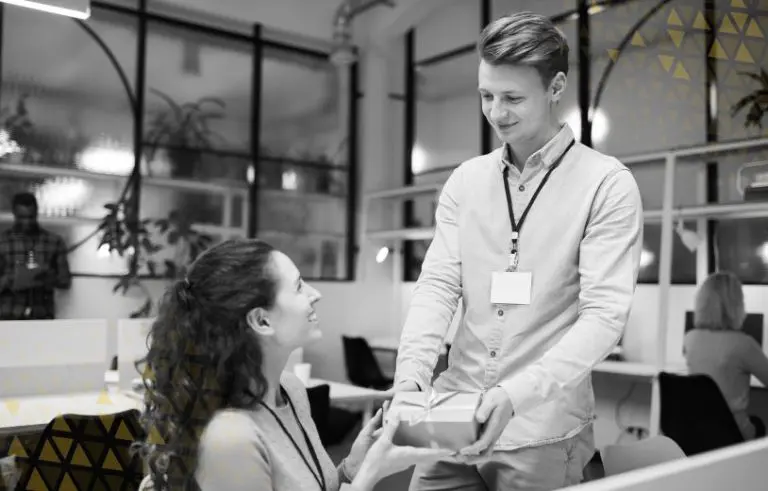 two employees, once handing another a gift