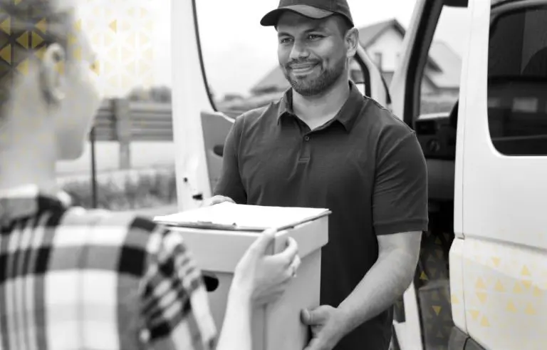 A delivery driver hands a happy customer their package.