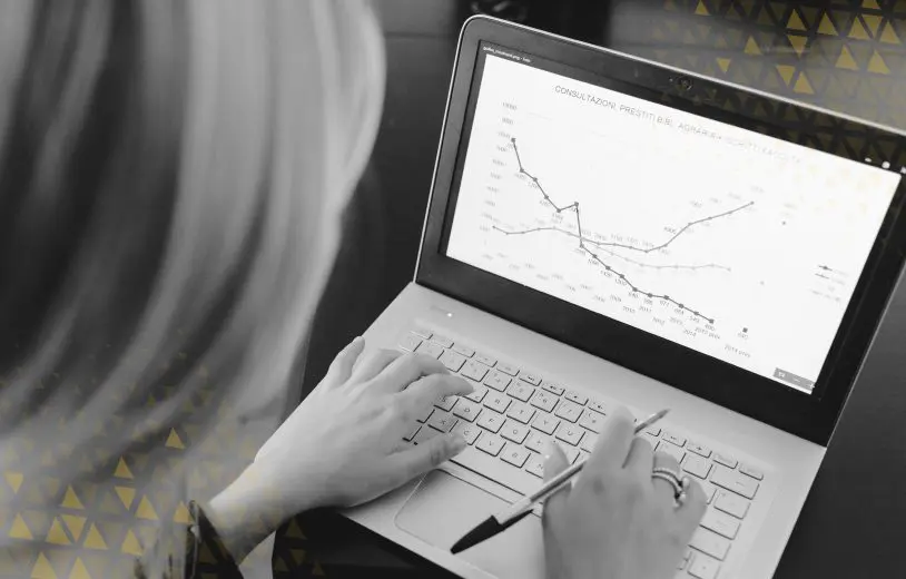 A woman looking at website analytics data on a laptop screen